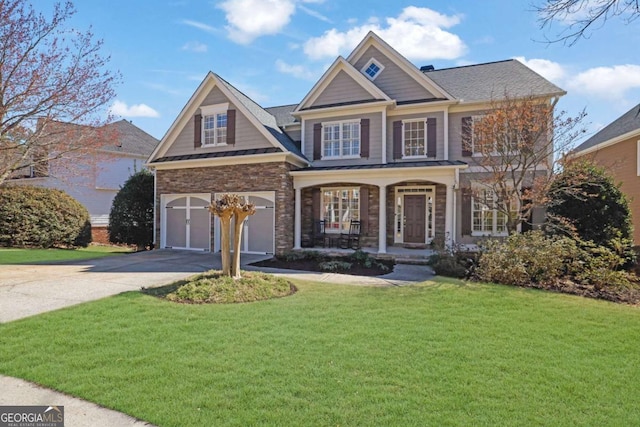 view of front of home with a front yard, a porch, an attached garage, concrete driveway, and stone siding