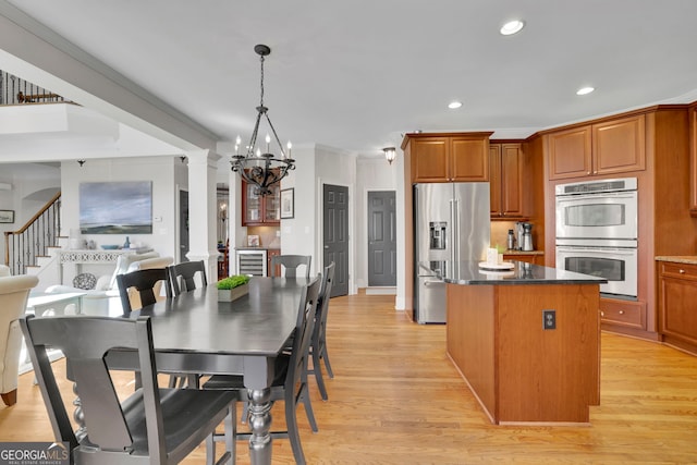 kitchen with beverage cooler, a kitchen island, light wood-style flooring, and stainless steel appliances