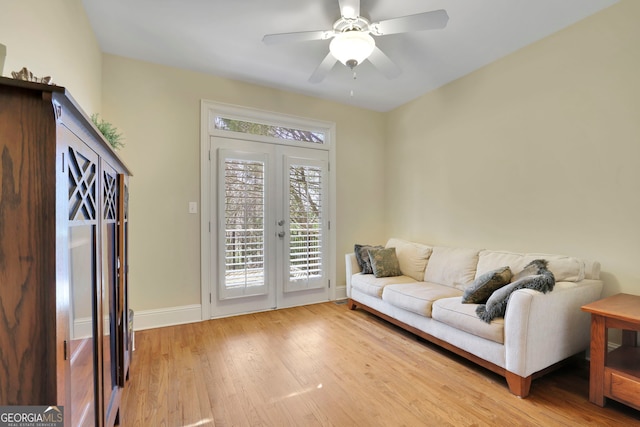 living area featuring french doors, baseboards, ceiling fan, and light wood finished floors