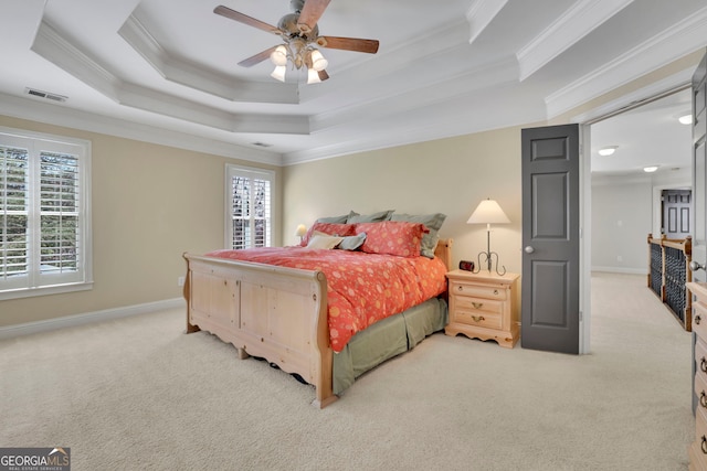 carpeted bedroom with baseboards, a tray ceiling, multiple windows, and visible vents