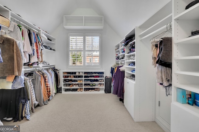 walk in closet featuring lofted ceiling and carpet