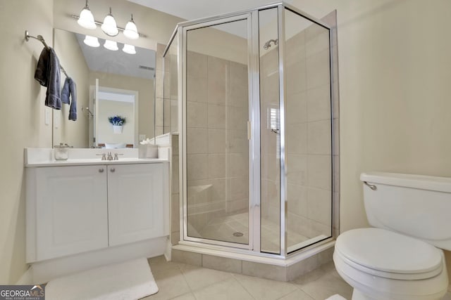 bathroom with vanity, tile patterned floors, toilet, and a stall shower