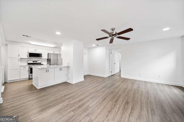 kitchen with open floor plan, visible vents, appliances with stainless steel finishes, and light wood-type flooring