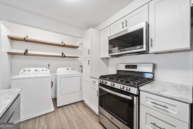 kitchen featuring washing machine and dryer, white cabinetry, stainless steel appliances, and open shelves