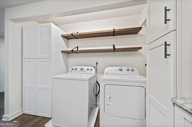 clothes washing area with baseboards, dark wood finished floors, and washing machine and clothes dryer