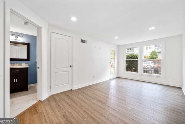spare room with recessed lighting, visible vents, light wood finished floors, and a sink