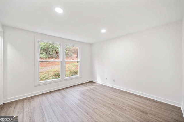 empty room with recessed lighting, baseboards, and wood finished floors