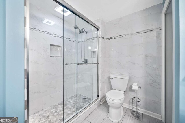 bathroom with toilet and a stall shower