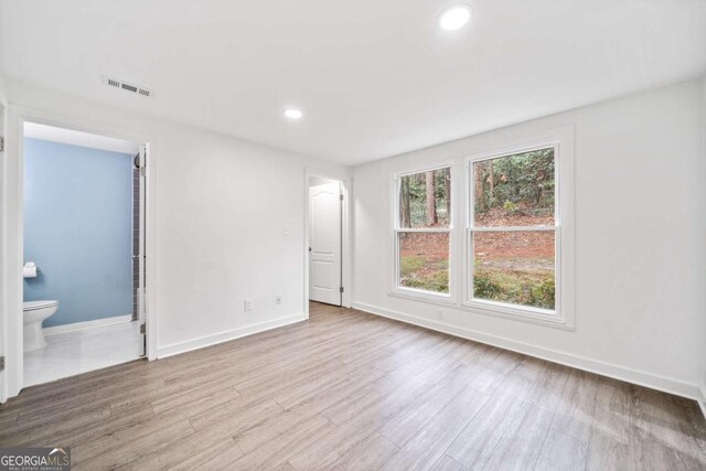 unfurnished bedroom with visible vents, recessed lighting, baseboards, and wood finished floors