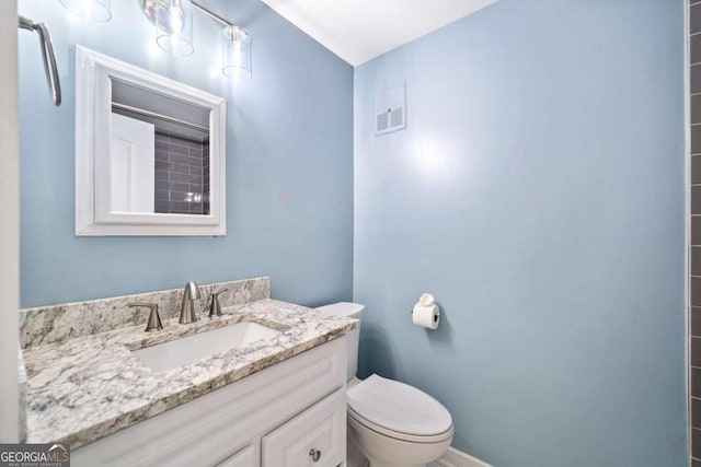 bathroom featuring vanity, toilet, and visible vents
