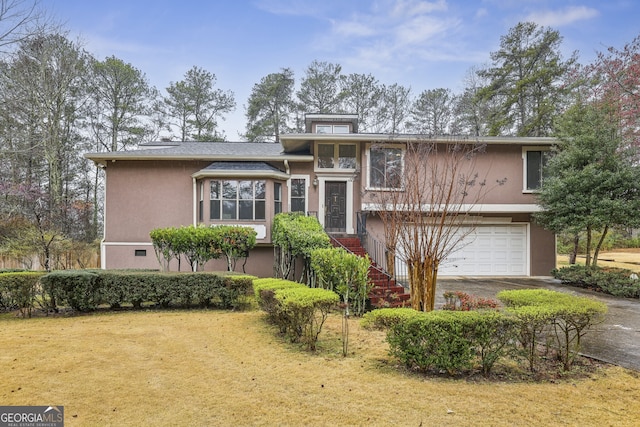 view of front of property with stucco siding, driveway, and a garage