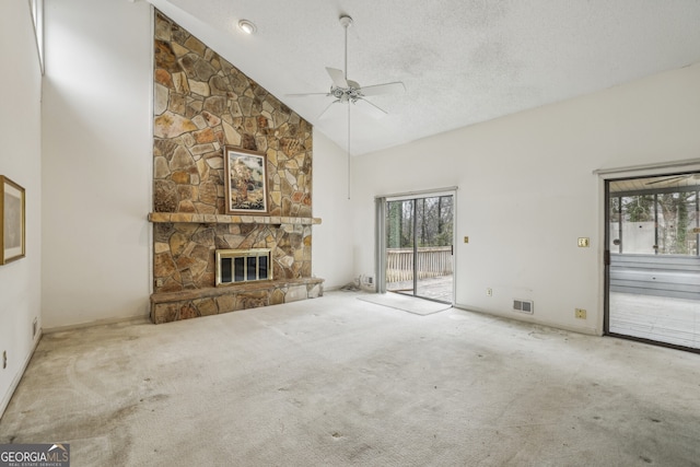 unfurnished living room with a stone fireplace, high vaulted ceiling, visible vents, and carpet floors