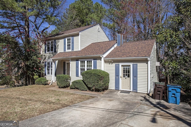 view of front of house featuring a shingled roof and a chimney