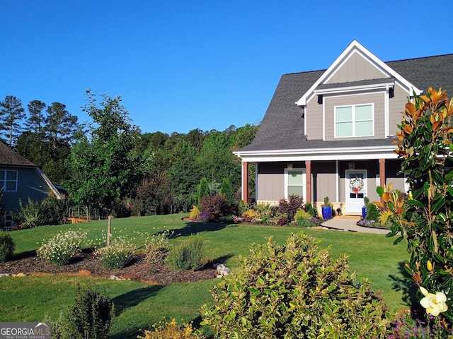 336 White Oak Way, Monroe, GA 30655 - view of front of home with board and batten siding, a front yard, and a shingled roof