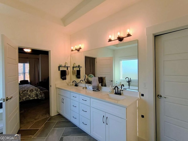 ensuite bathroom with double vanity, connected bathroom, and a sink