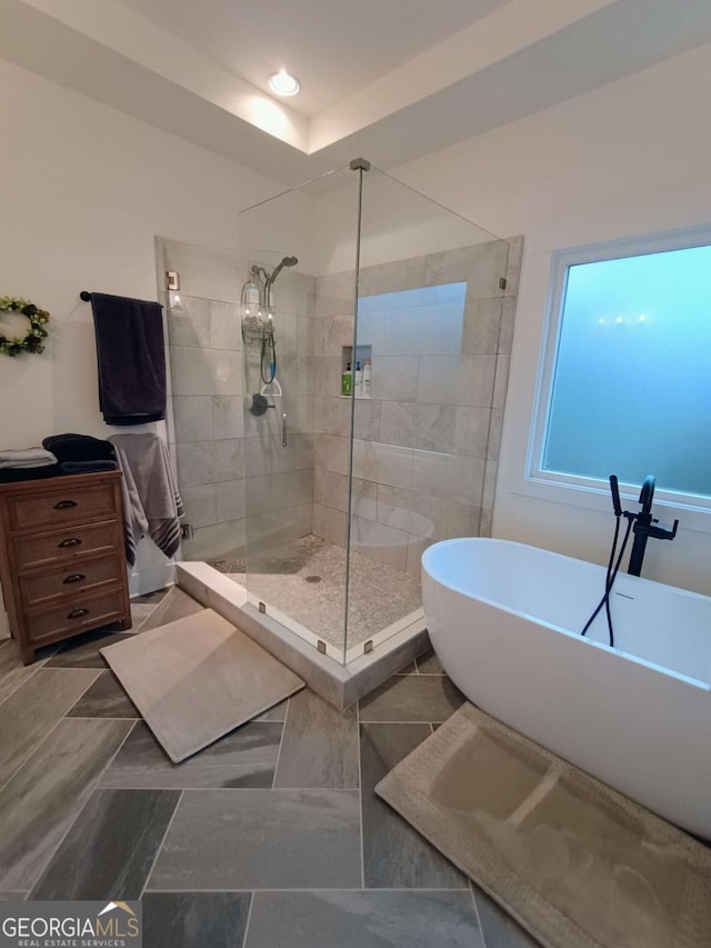 full bath featuring a soaking tub and a stall shower