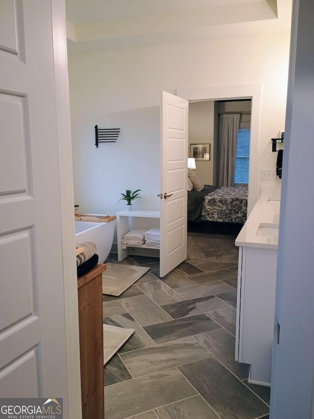 ensuite bathroom with a freestanding tub, ensuite bathroom, and vanity