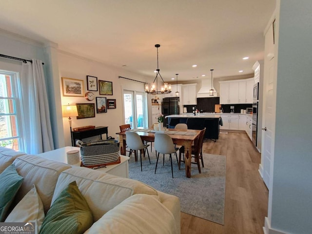 dining area with recessed lighting, a chandelier, and light wood finished floors