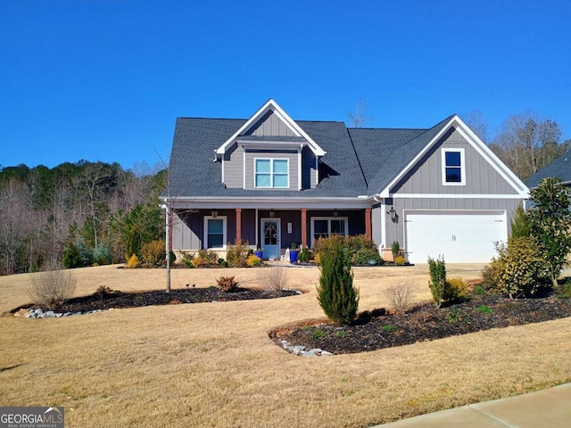 craftsman inspired home featuring board and batten siding, a front lawn, a porch, a garage, and driveway