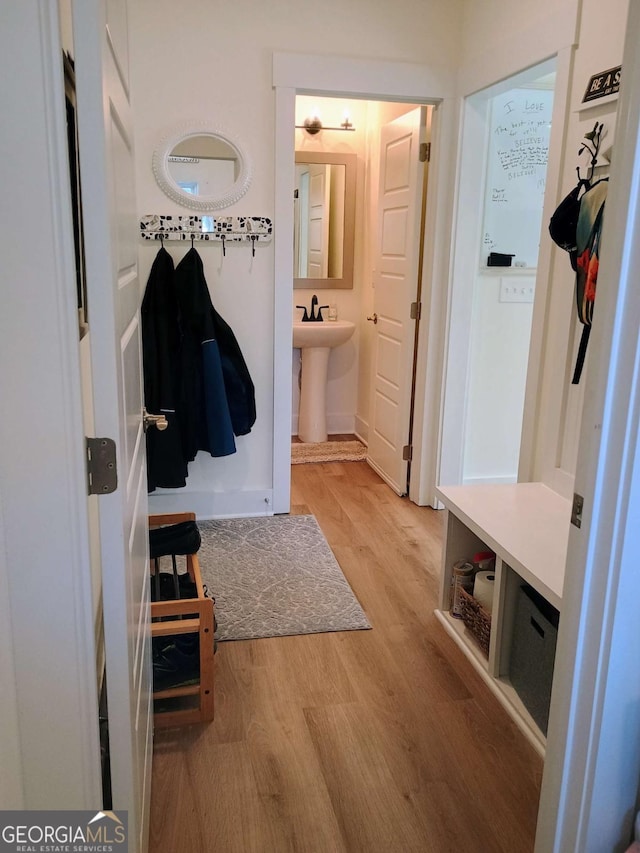 mudroom featuring light wood-type flooring and a sink