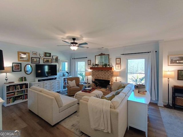 living area featuring a ceiling fan, wood finished floors, and a fireplace