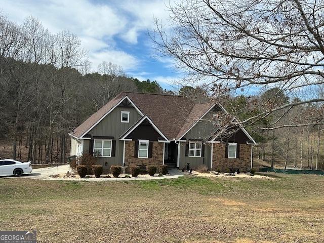 craftsman inspired home featuring stone siding and a front yard