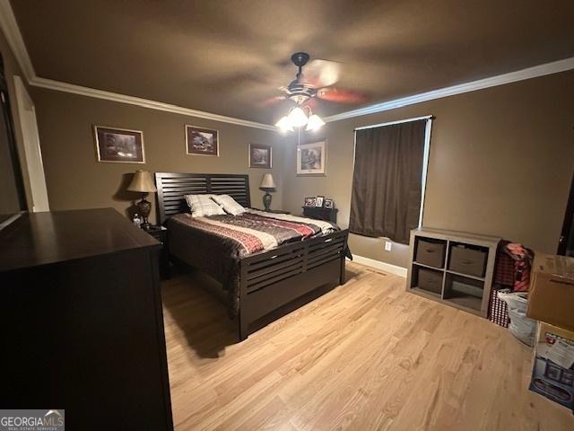 bedroom featuring ornamental molding, ceiling fan, and wood finished floors