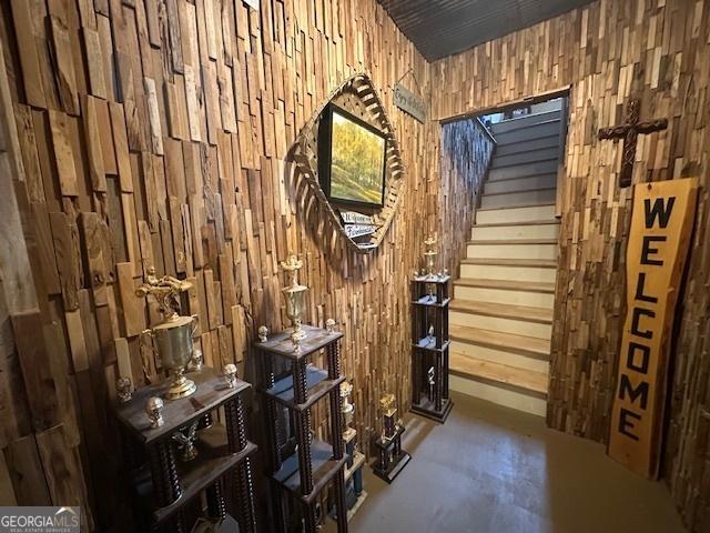 wine room featuring concrete flooring and wood walls