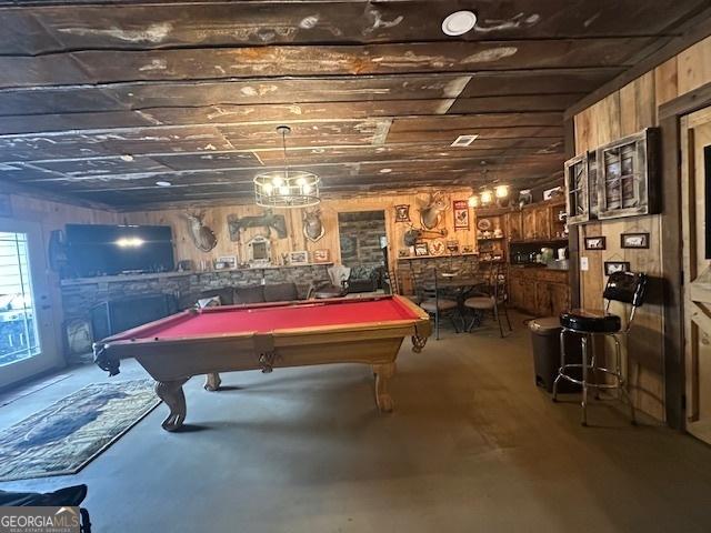 recreation room featuring wooden walls, concrete floors, and billiards