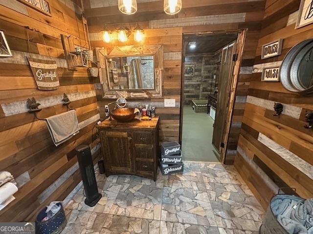 interior space featuring wooden walls, a stall shower, and vanity