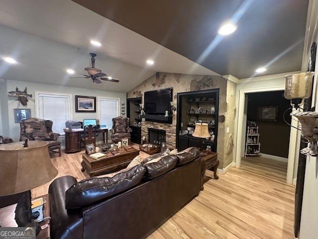 living area with light wood-type flooring, recessed lighting, a fireplace, lofted ceiling, and ceiling fan