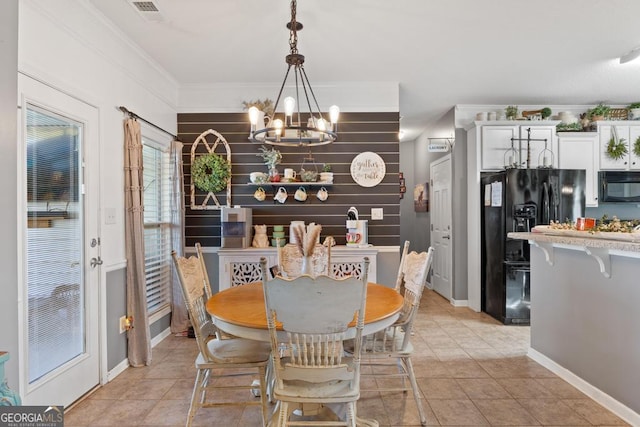 dining space with light tile patterned floors, baseboards, visible vents, an inviting chandelier, and ornamental molding