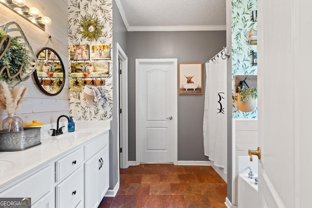 bathroom featuring baseboards, vanity, ornamental molding, a bathing tub, and a textured ceiling