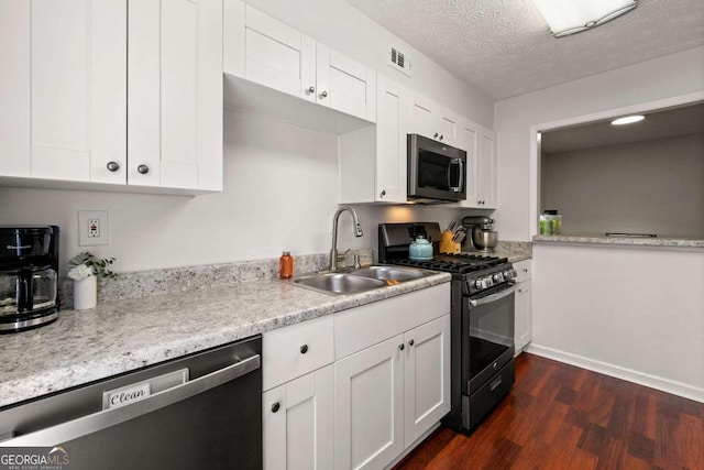 kitchen featuring visible vents, a sink, black gas range, dishwasher, and stainless steel microwave