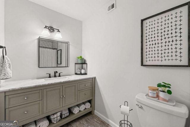 bathroom with visible vents, baseboards, toilet, and vanity