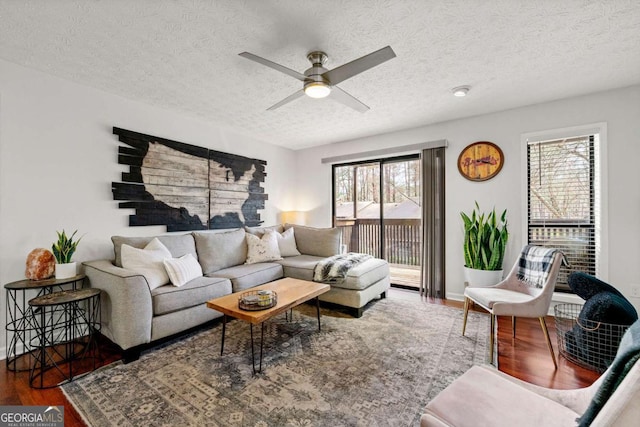 living area with a ceiling fan, wood finished floors, and a textured ceiling