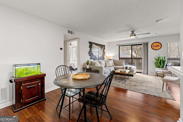 dining area featuring dark wood-type flooring, visible vents, and ceiling fan