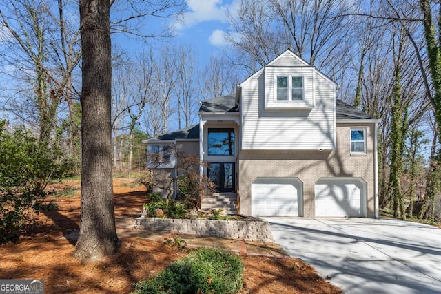 view of front facade with concrete driveway, an attached garage, and brick siding