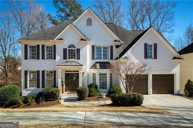 view of front of home featuring a garage, brick siding, roof with shingles, and driveway