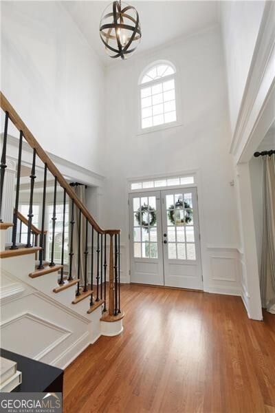 entryway with stairway, french doors, and wood finished floors