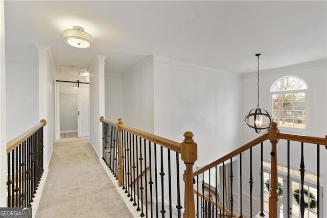 hallway with an upstairs landing, carpet flooring, crown molding, and a barn door