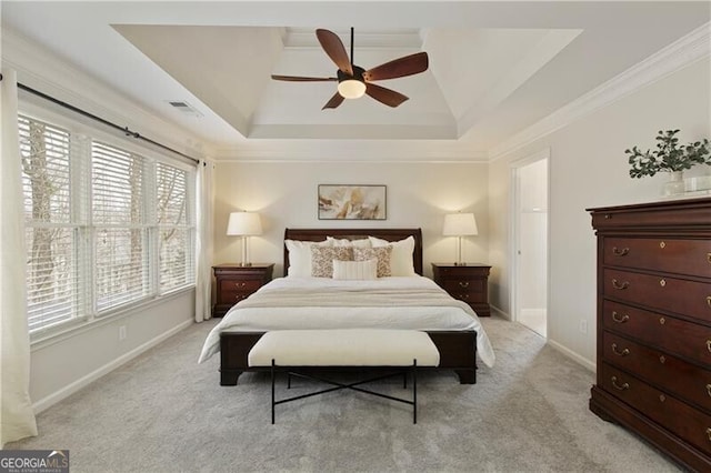 bedroom with visible vents, baseboards, a tray ceiling, crown molding, and light colored carpet