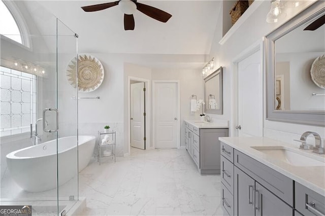 bathroom with marble finish floor, two vanities, a sink, a shower stall, and a freestanding bath