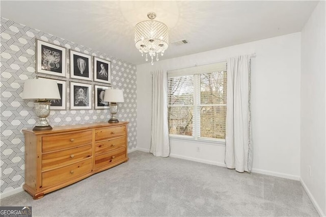 unfurnished bedroom with visible vents, baseboards, wallpapered walls, a notable chandelier, and light colored carpet