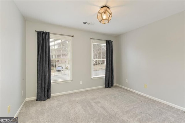 spare room with visible vents, baseboards, and carpet floors