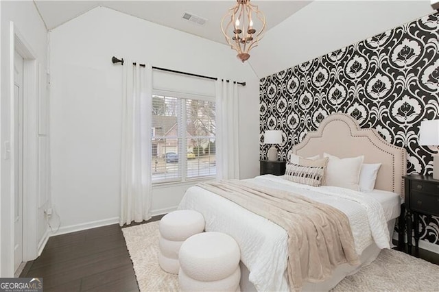 bedroom featuring visible vents, baseboards, an inviting chandelier, and wood finished floors