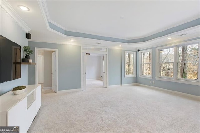 interior space featuring light carpet, baseboards, crown molding, and a tray ceiling