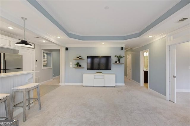 unfurnished living room featuring a raised ceiling, crown molding, light colored carpet, and baseboards