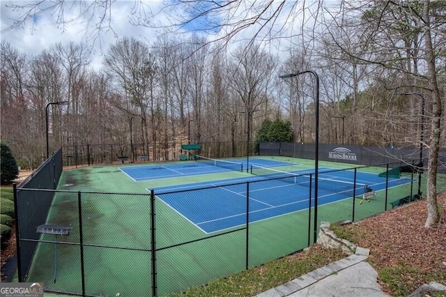 view of tennis court featuring fence