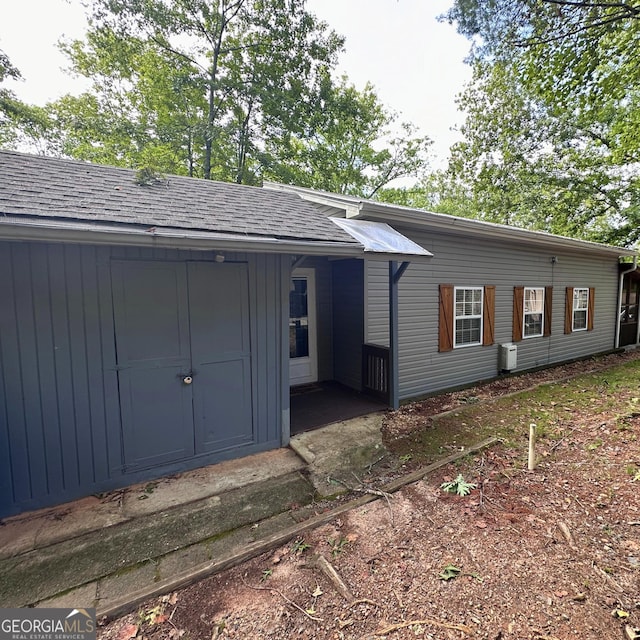 back of property with roof with shingles